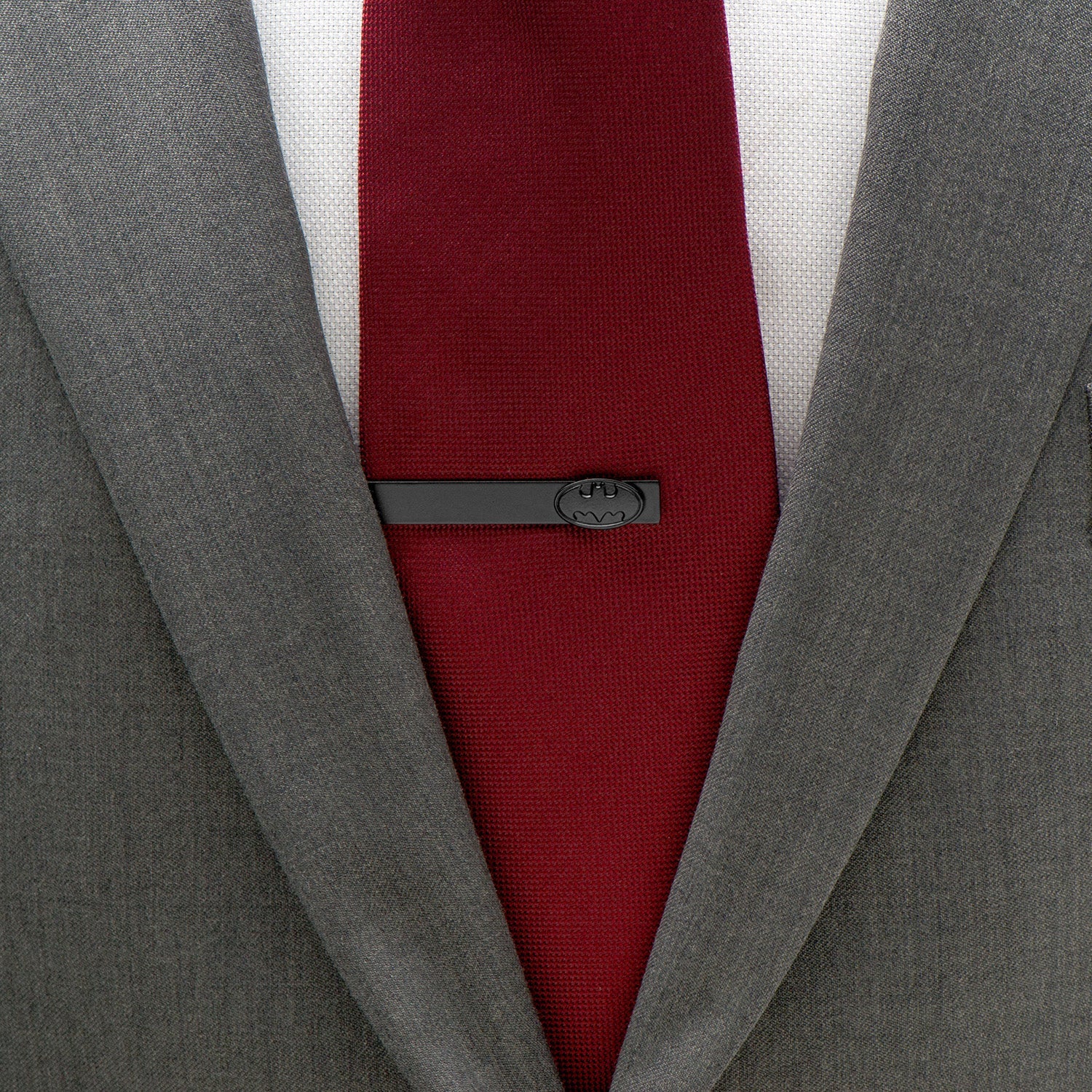 Gray suit jacket with a red tie and gray tie clip on a white background