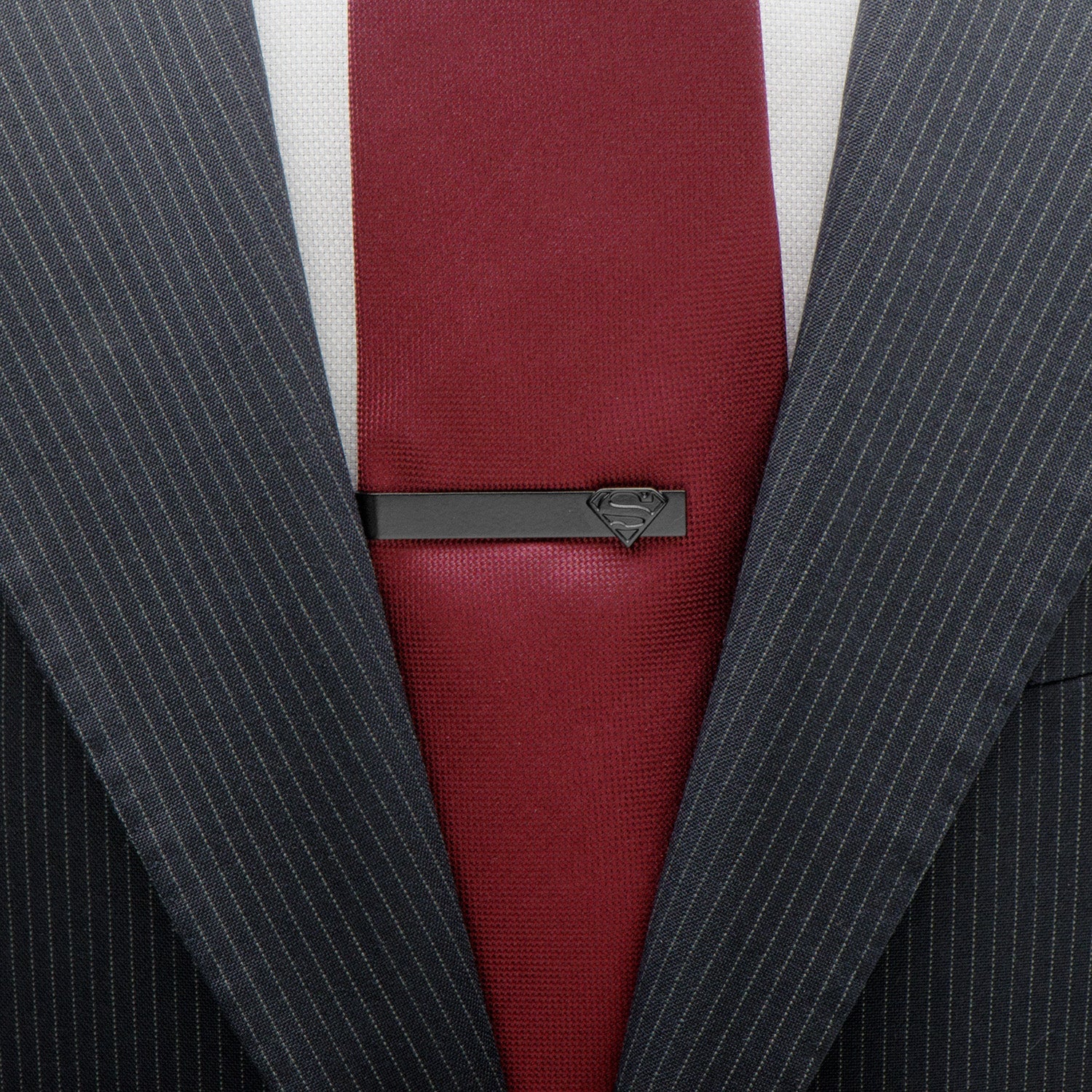 Gray pinstripe suit with a red tie and Superman tie clip