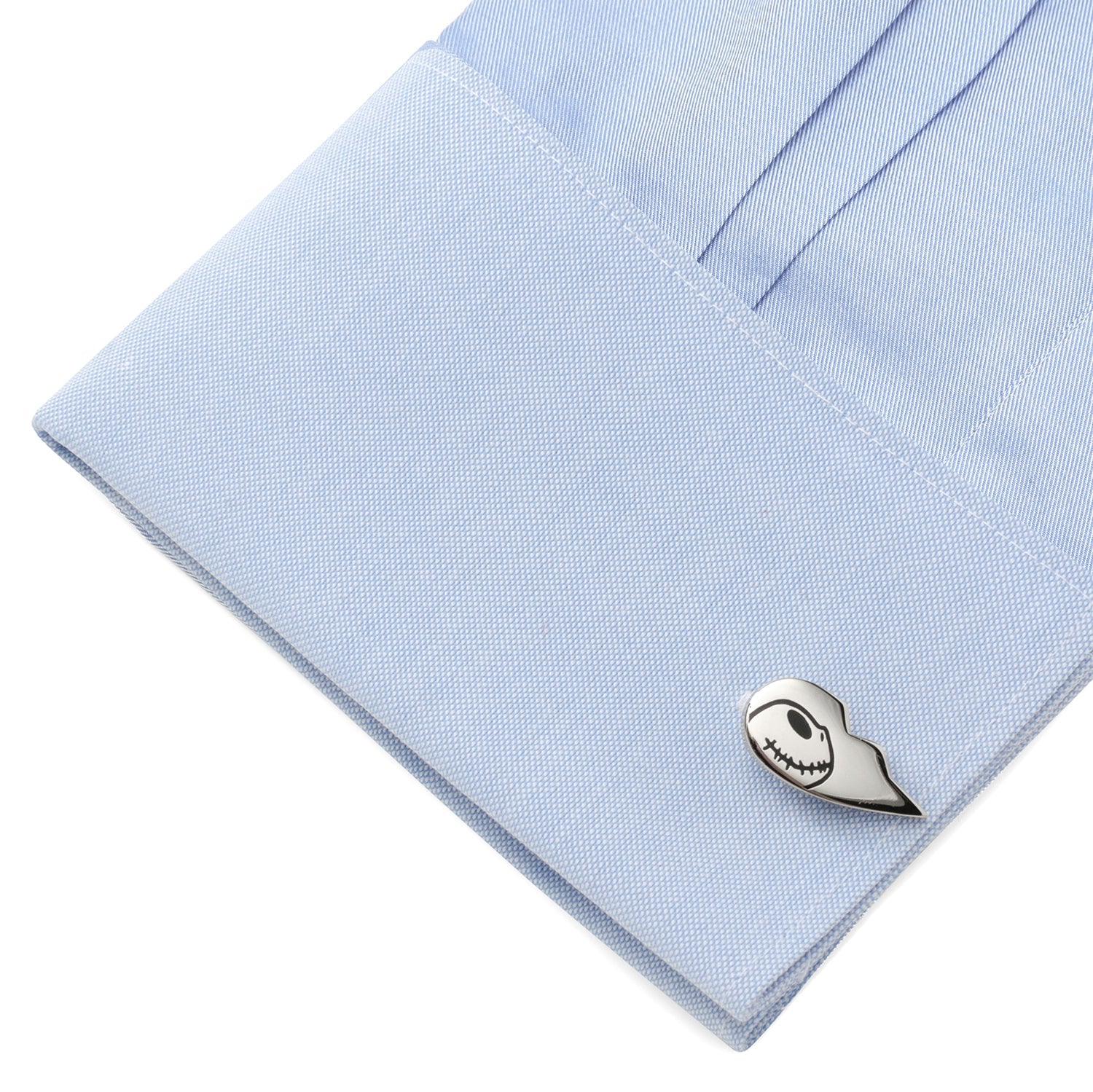 Cufflink on a light blue shirt with a white background
