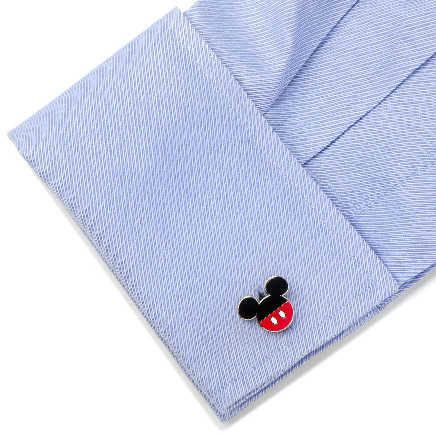 Cufflink with a cartoon character design on a blue striped shirt cuff.