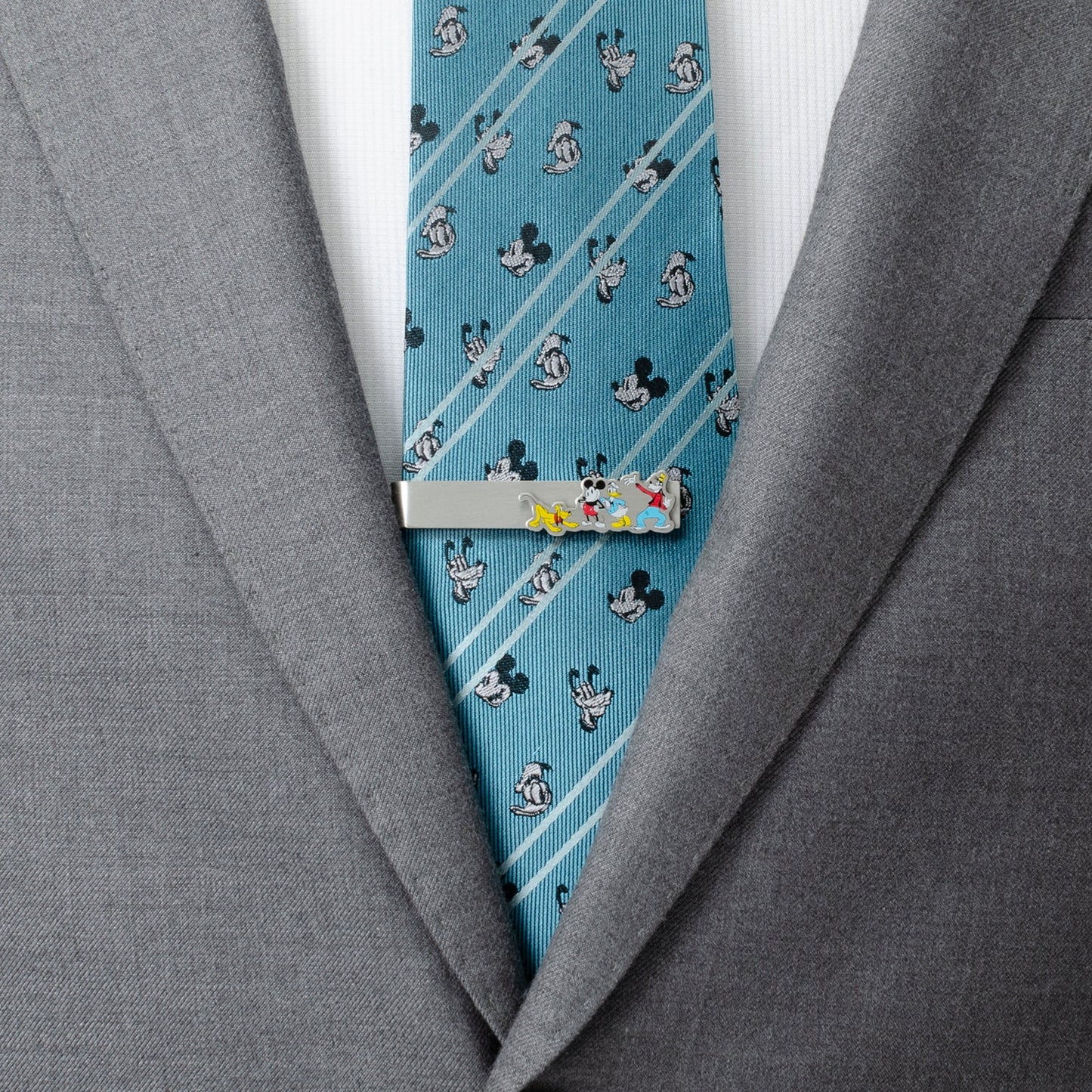 Blue tie with cartoon character pattern and silver tie clip on gray suit jacket Mickey and Friends 