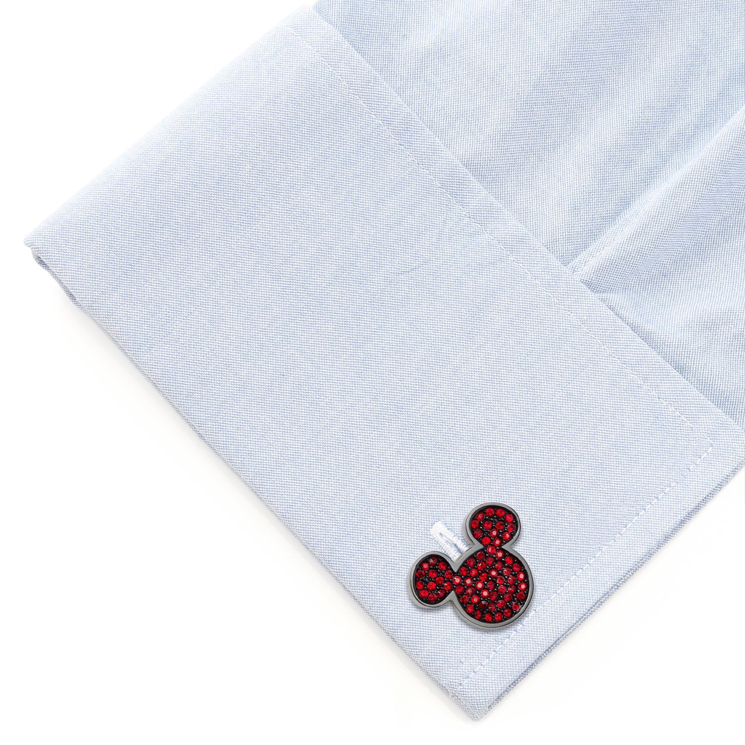 Cufflinks with a red and black design on a light blue shirt