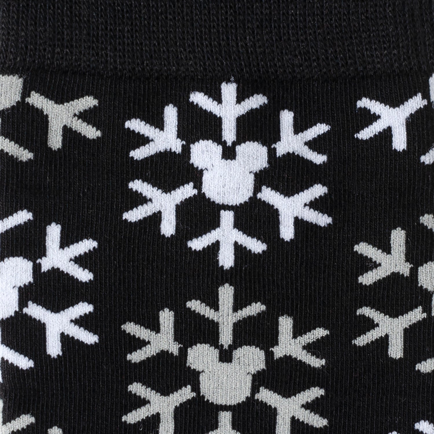 Black socks with white snowflake patterns featuring Mickey Mouse heads on a black background
