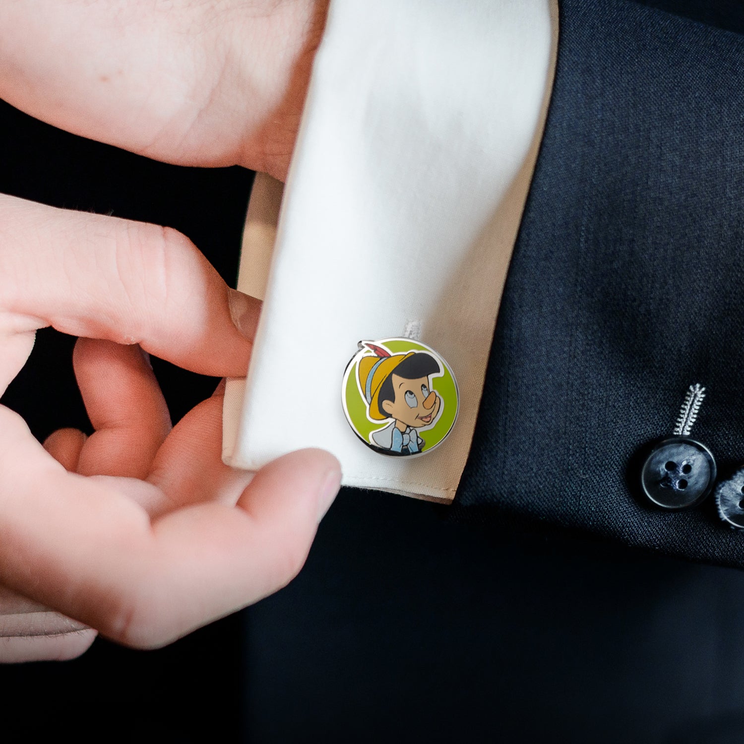 Cufflink with cartoon character design being worn on a suit cuff
