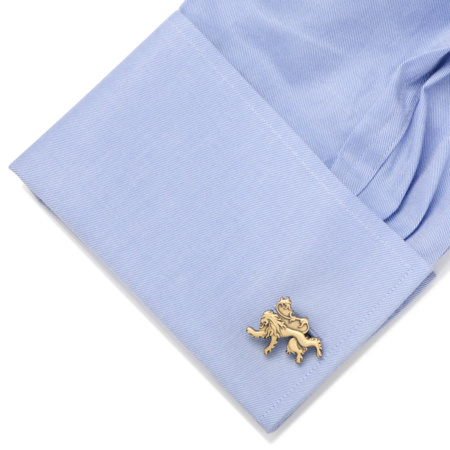 Gold lion cufflink on a light blue shirt cuff