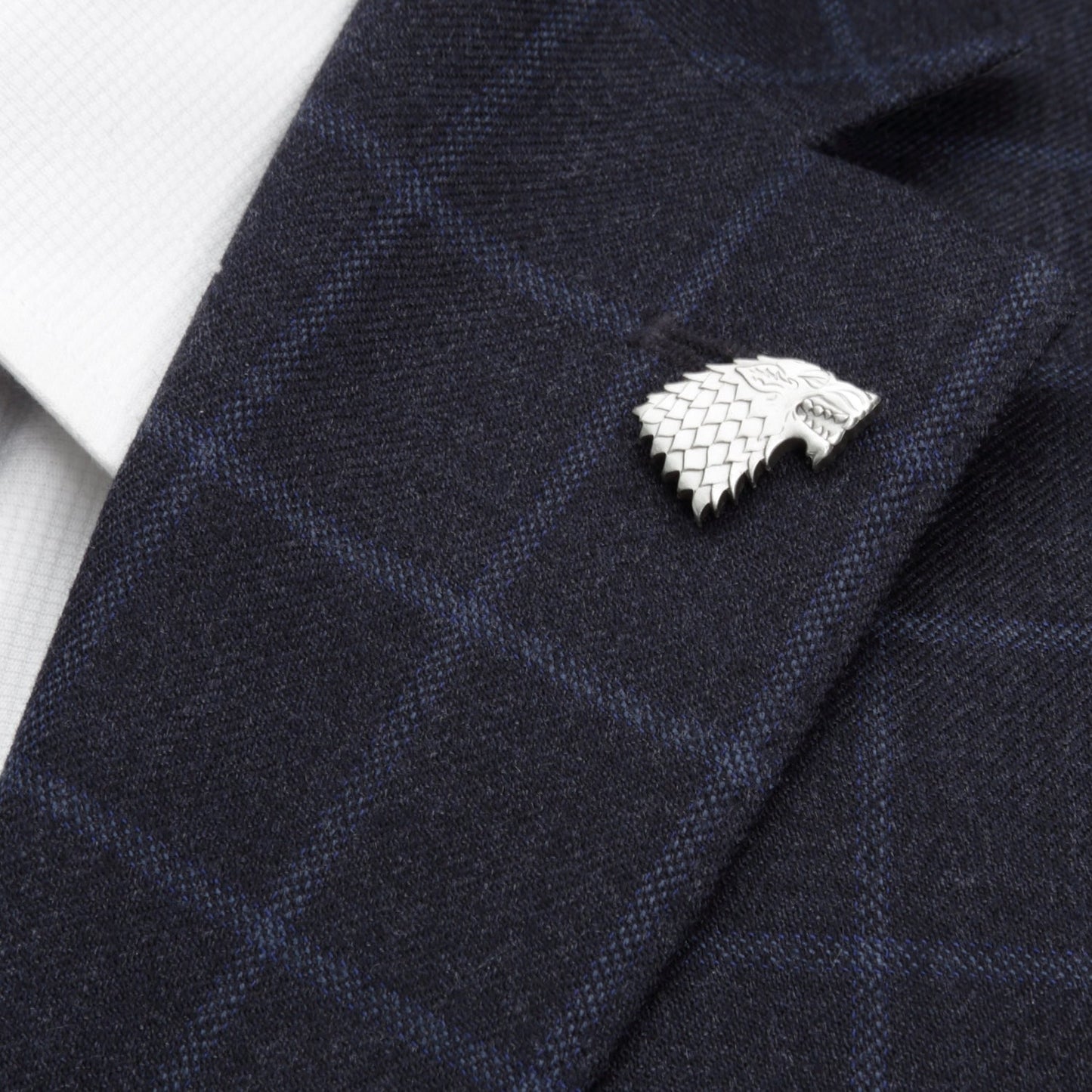 Silver House Stark pin on a dark blue textured fabric