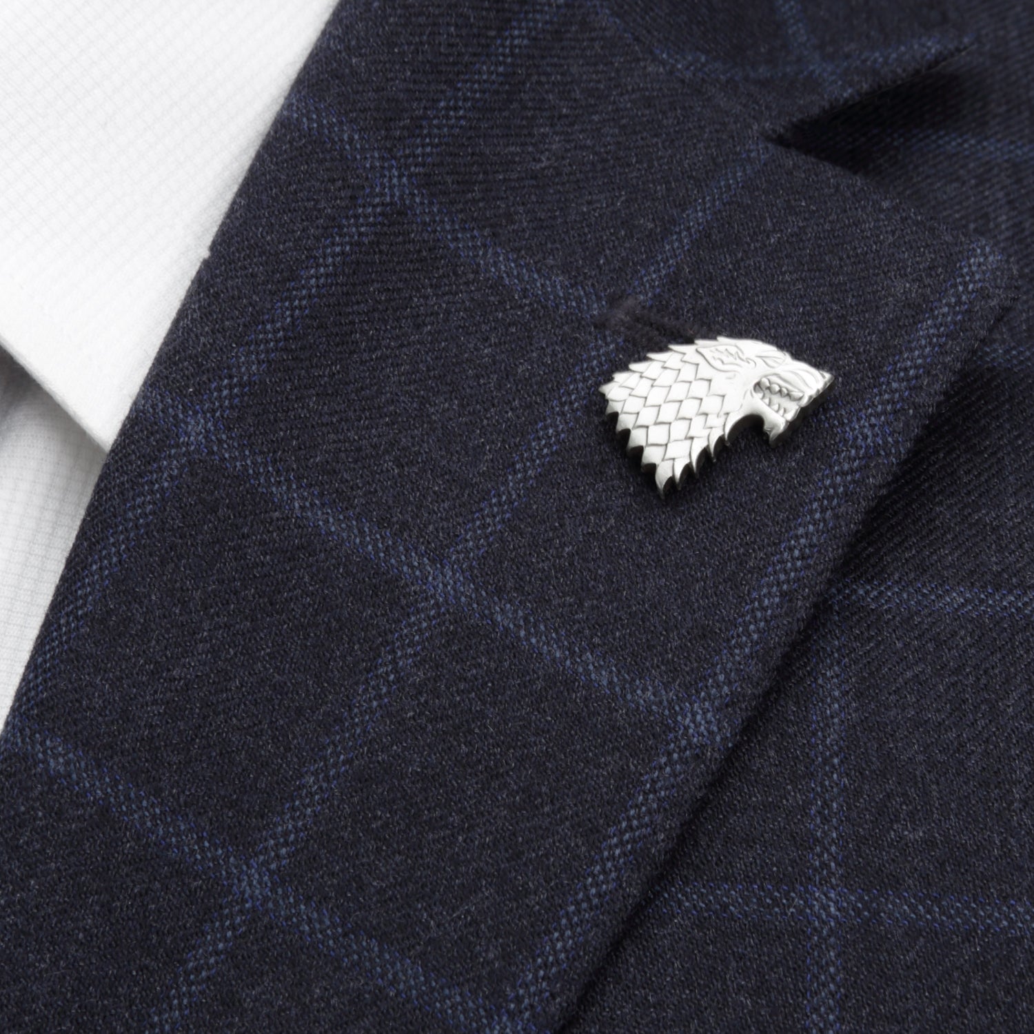 Silver House Stark pin on a dark blue textured fabric