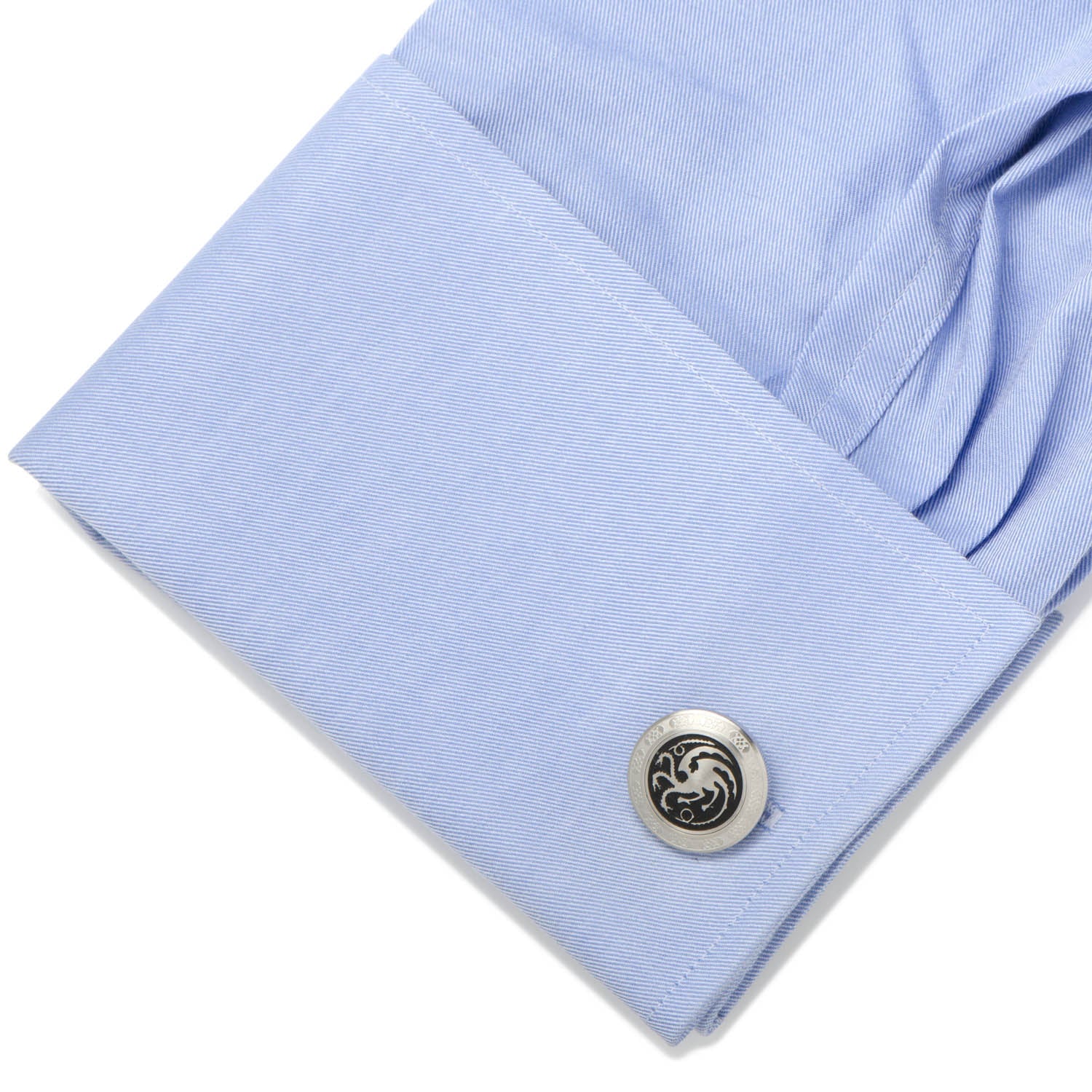 Close-up of a light blue shirt cuff with a cufflink on a white background