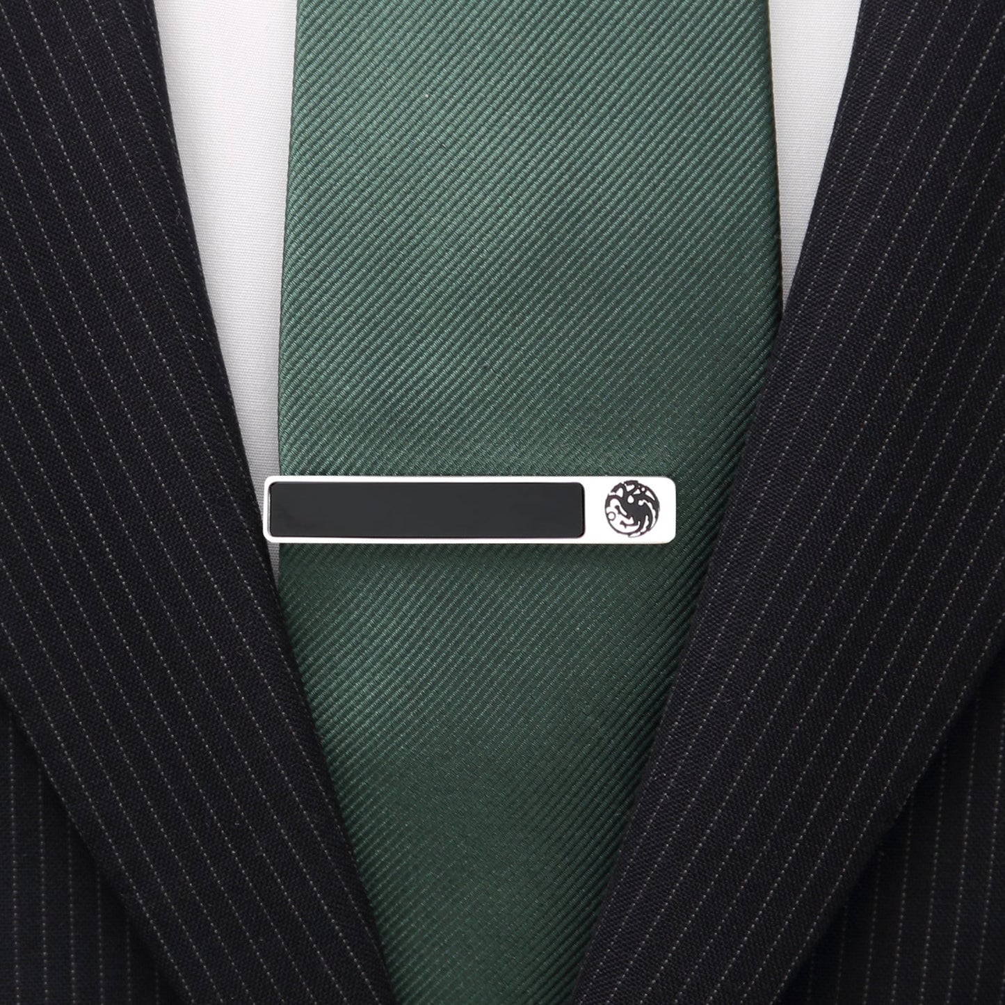 Green tie with a silver tie clip on a black pinstripe suit jacket