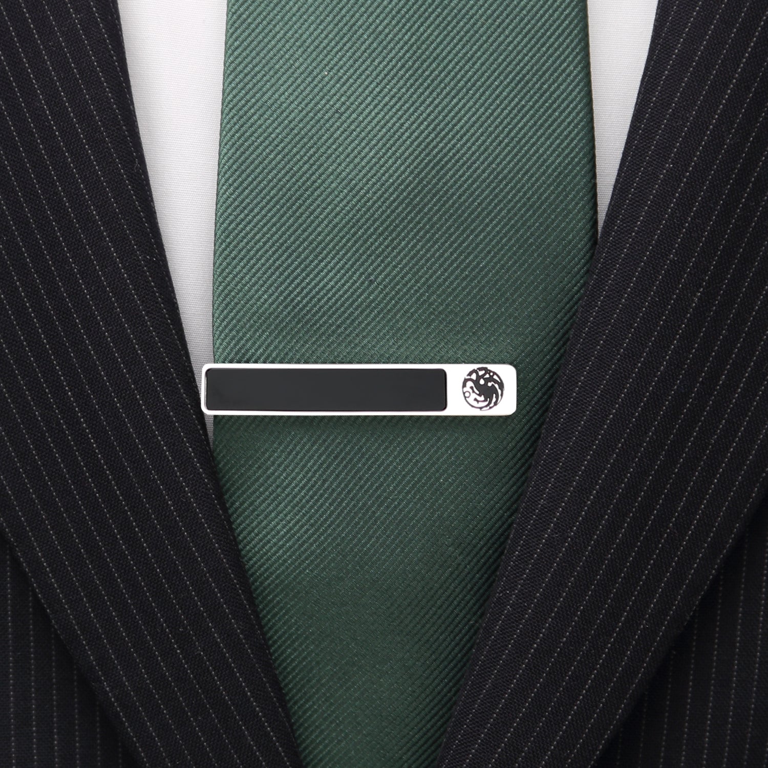 Green tie with a silver tie clip on a black pinstripe suit jacket