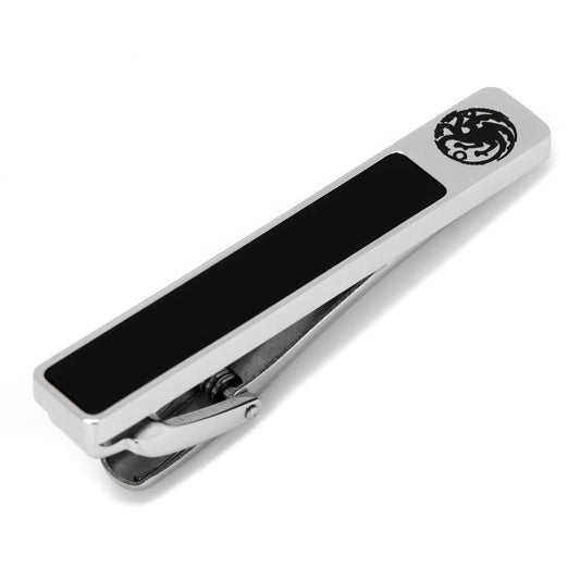 Metallic tie clip with black center and emblem on a white background