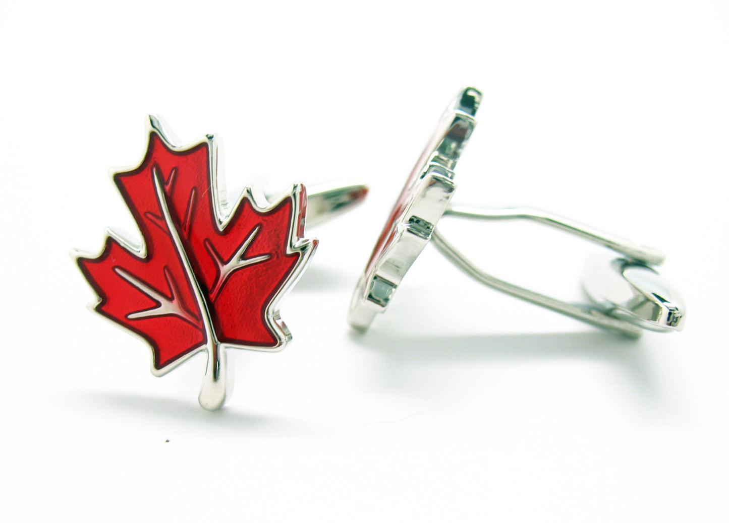 Red maple leaf cufflinks in silver and red enamel displayed on white background.
