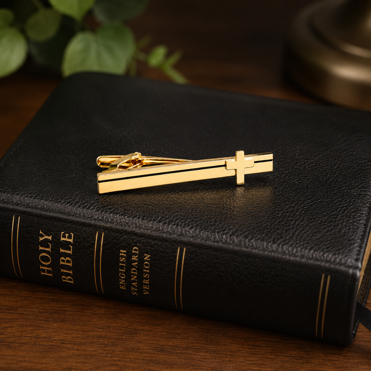 Gold Cross tie clip on a black Bible