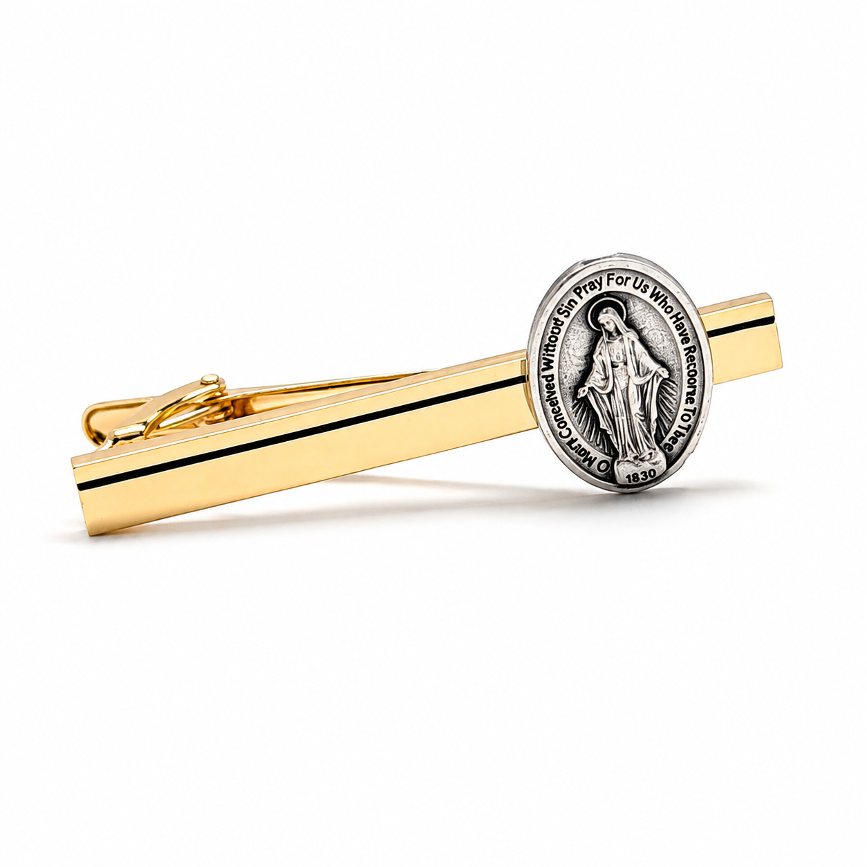A gold tie bar with a silver-toned oval religious medallion featuring a standing figure and engraved text, shown on a clean white background.