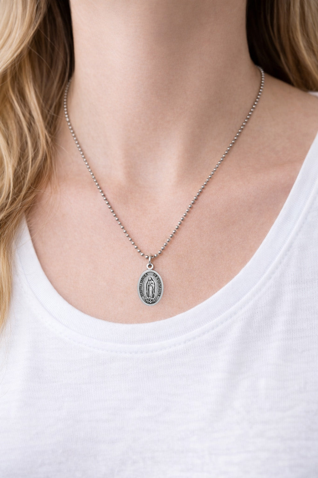 Our Lady of Guadalupe Medal Necklace with a pendant worn by a person in a white top