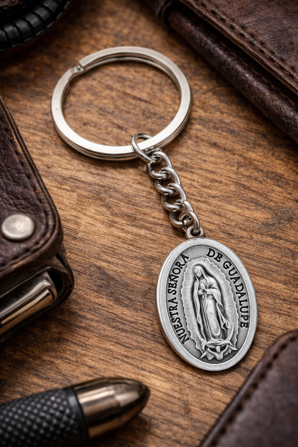 Our Lady of Guadalupe Catholic keychain with Virgin Mary medal on wooden background 