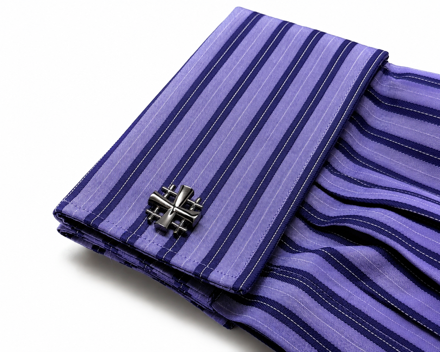 A folded purple and navy striped dress shirt cuff with a silver-toned metal cufflink, shown on a clean white background.