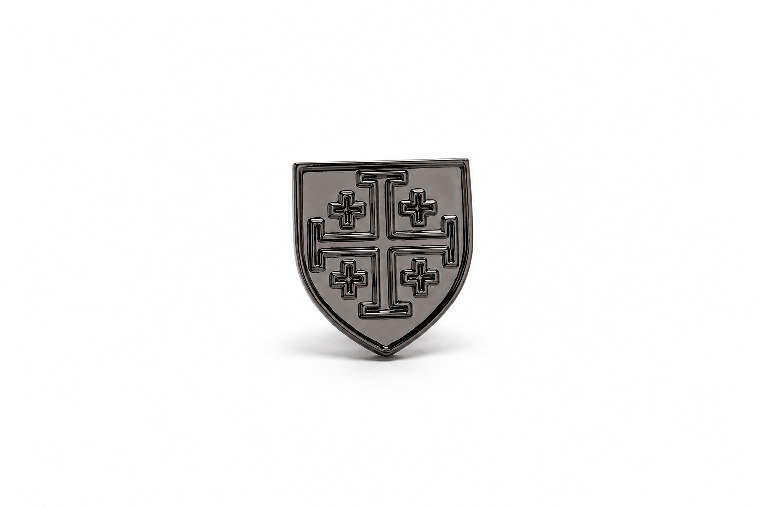 A small shield-shaped black enamel pin featuring a raised cross design, centered on a plain white background.