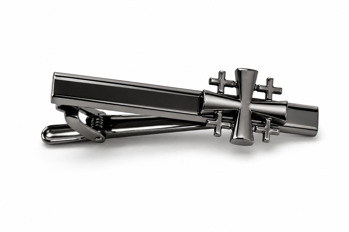 A dark gunmetal gray Gunmetal Jerusalem Cross Tie Clip featuring a polished cross design on the bar, set against a clean white background.