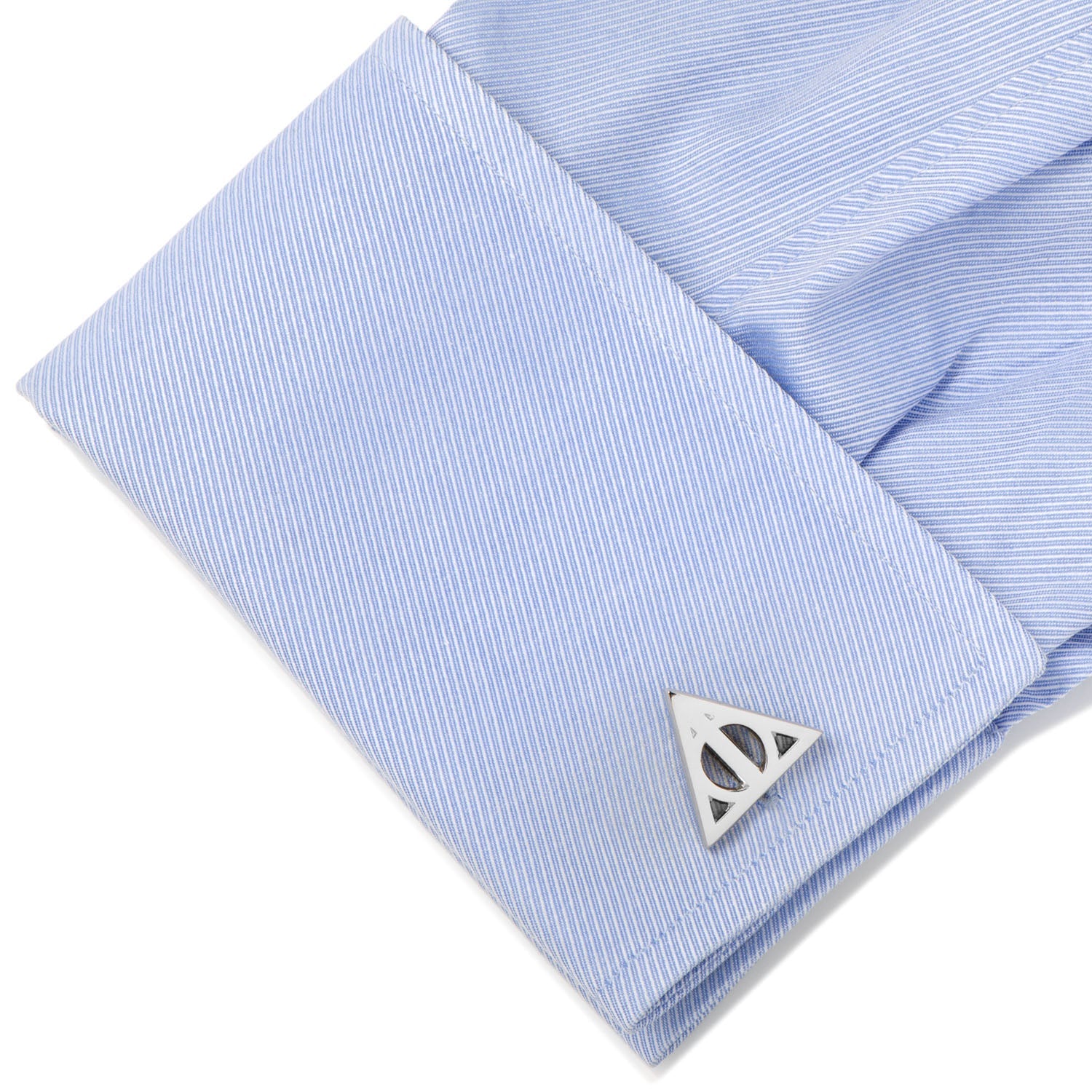 Cufflink with a geometric design on a light blue striped shirt
