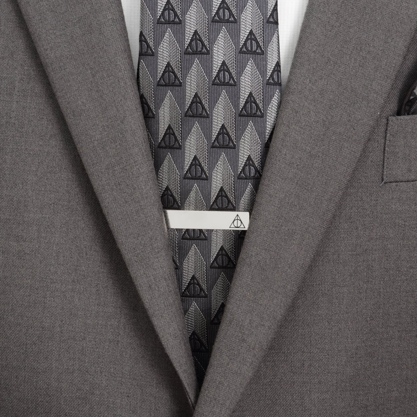 Gray suit with a patterned tie and tie clip