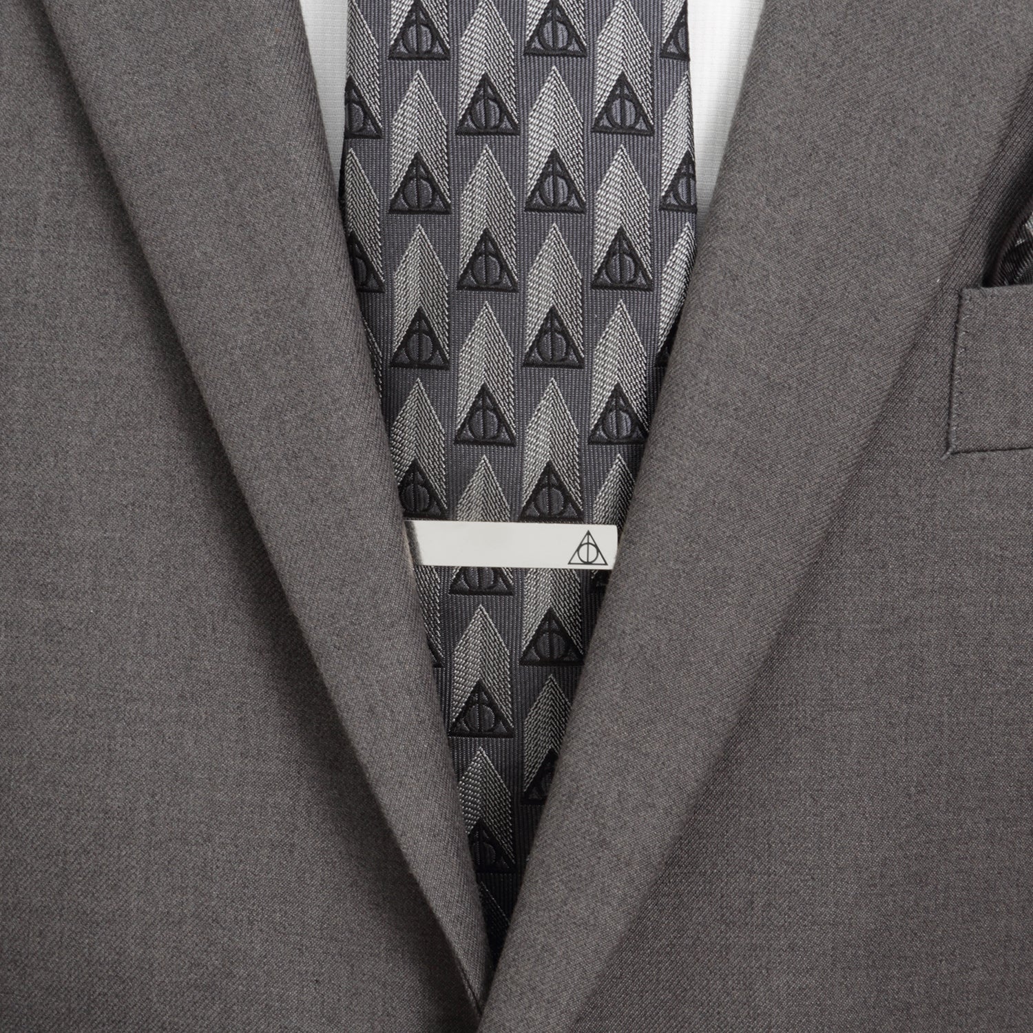 Gray suit with a patterned tie and tie clip