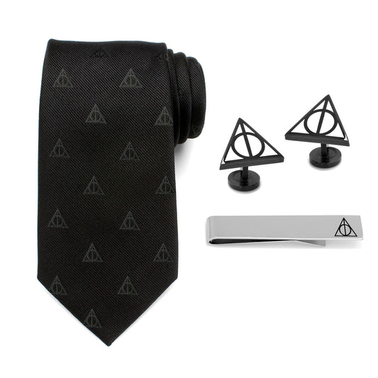 Black tie with Deathly Hallows pattern, two black cufflinks, and a silver tie clip on a white background