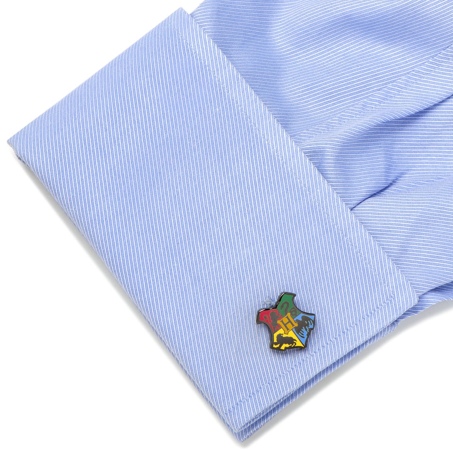 Close-up of a light blue striped shirt with a colorful emblem on the cuff.