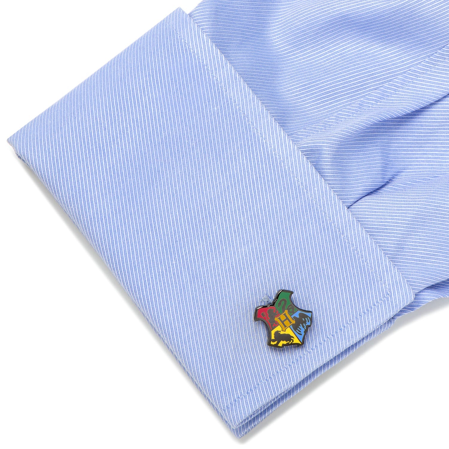 Close-up of a light blue striped shirt with a colorful emblem on the cuff.