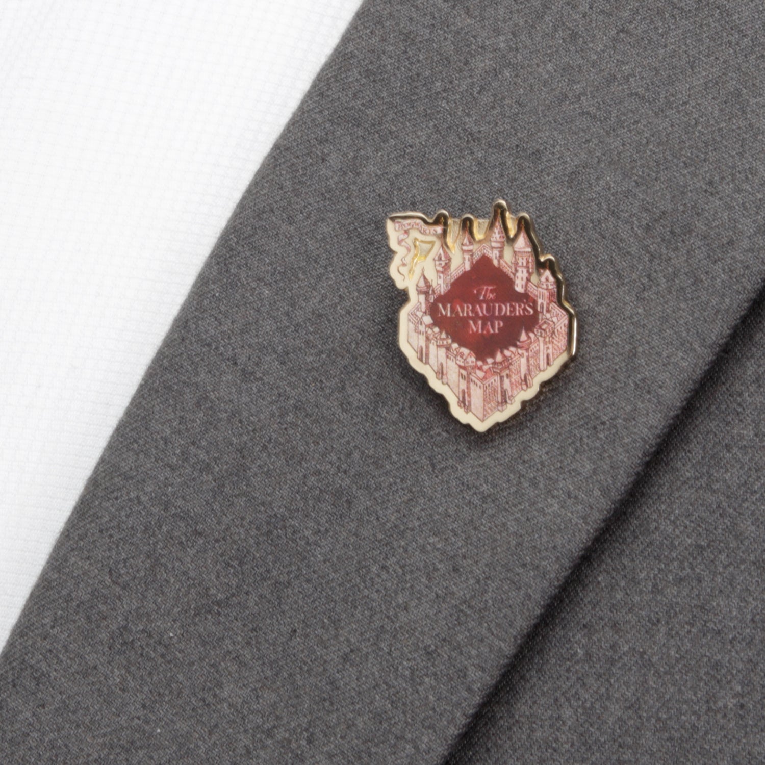 Pin with 'The Marauder's Map' design on a gray fabric background