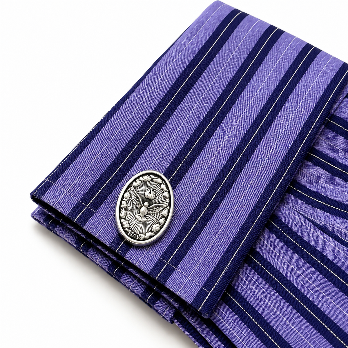 A folded purple striped dress shirt cuff with a decorative silver oval cufflink, shown on a clean white background. Holy Spirit Dove cufflinks