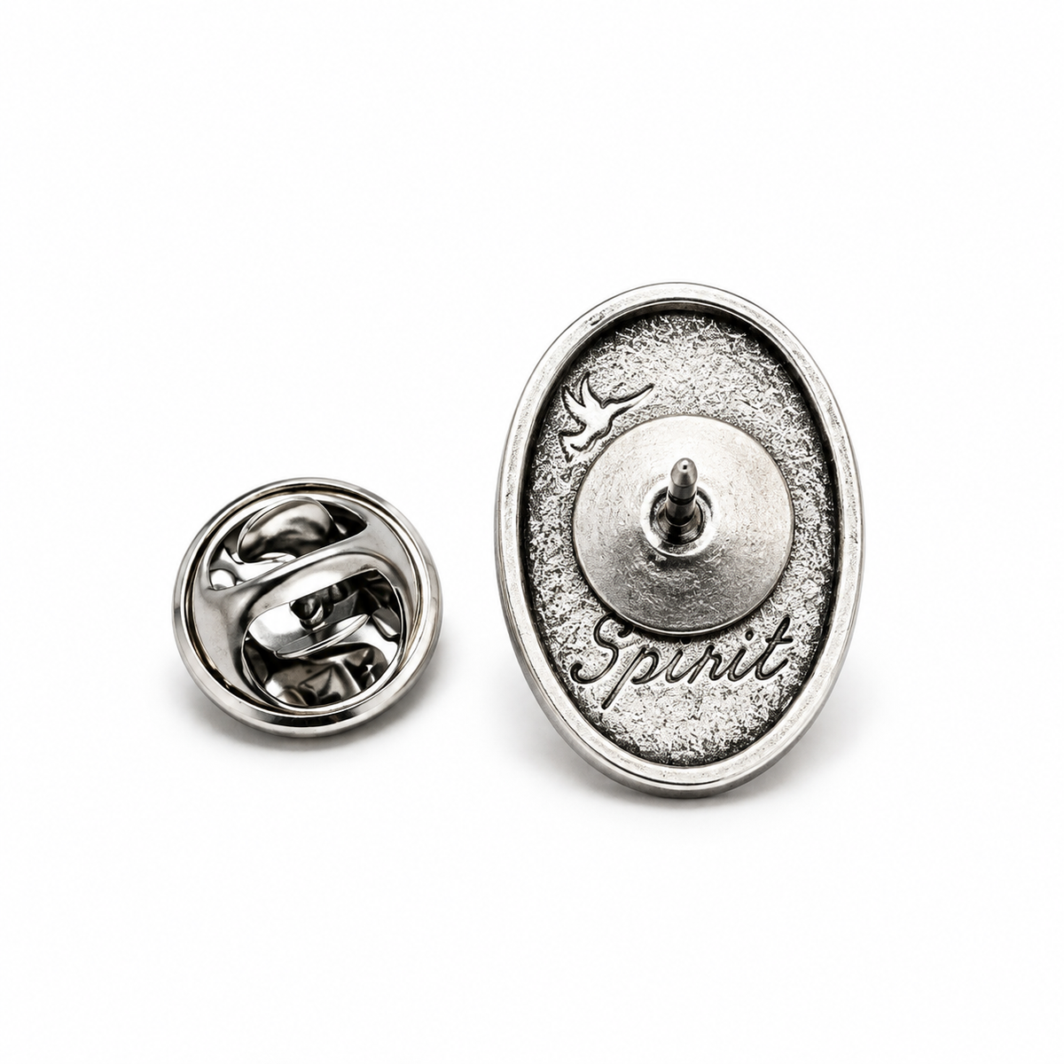 A silver oval lapel pin shown from two angles on a white background. One view shows the textured front with the word 'Spirit' and a small bird, while the other shows the polished clasp back.