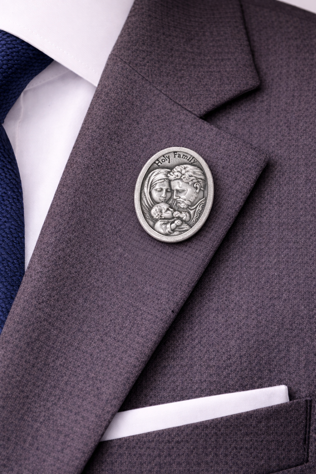 Close-up of a gray suit jacket with a decorative button featuring Holy Family design.