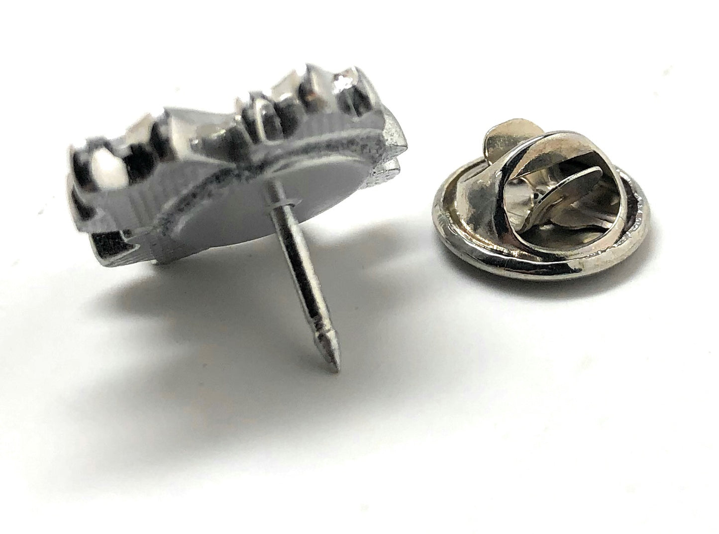 Red maple leaf lapel pin with silver outline and butterfly clasp displayed on white background