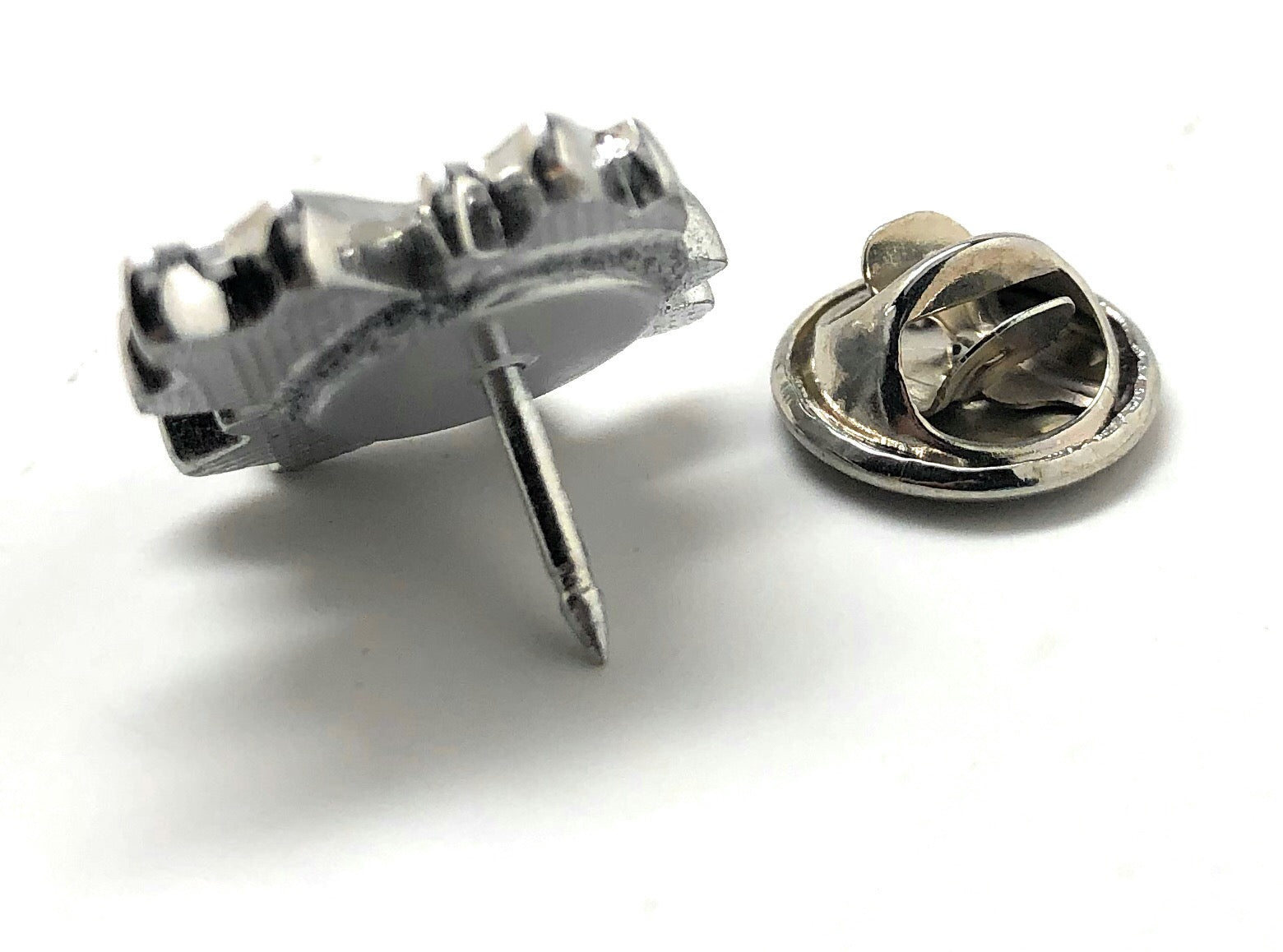 Red maple leaf lapel pin with silver outline and butterfly clasp displayed on white background