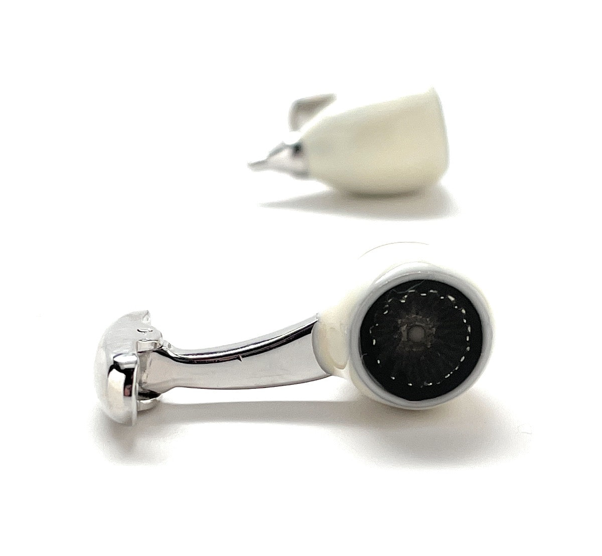 Cufflinks with a silver design and black center on a white background