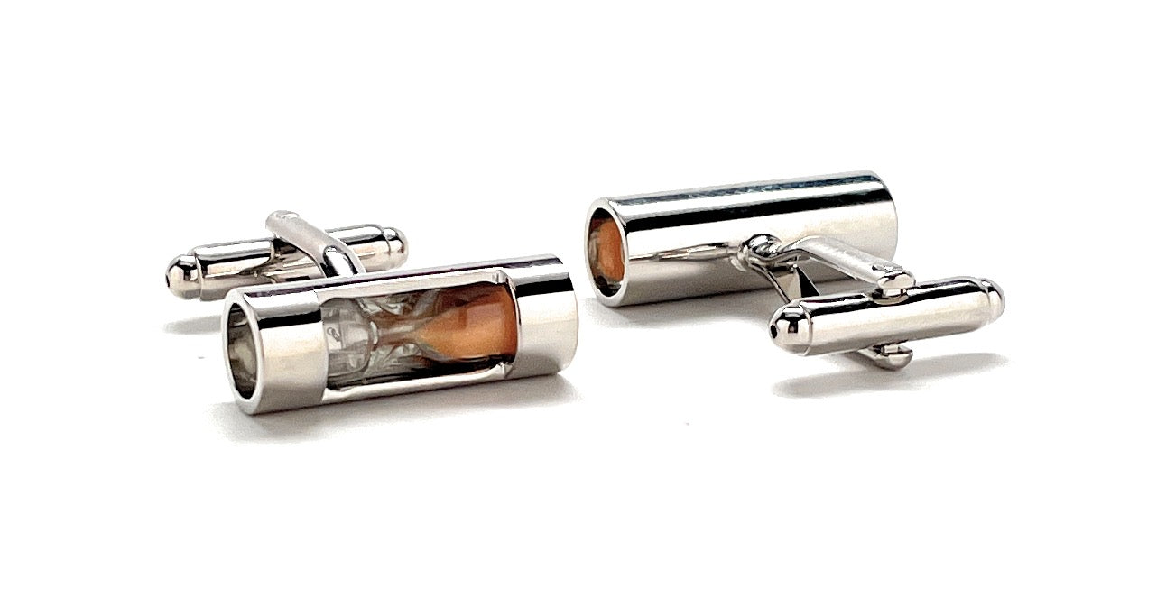 Silver cylindrical cufflinks with a central brown gemstone on a white background