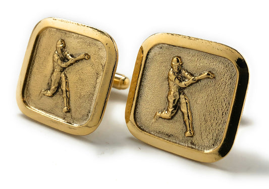 Gold cufflinks with a engraved figure on a white background