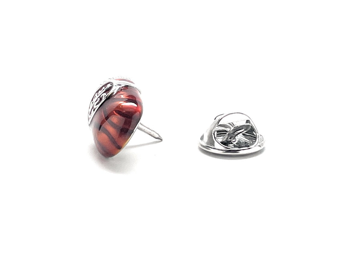 Two rings, one with a red and black pattern and the other with a silver design, on a white background.