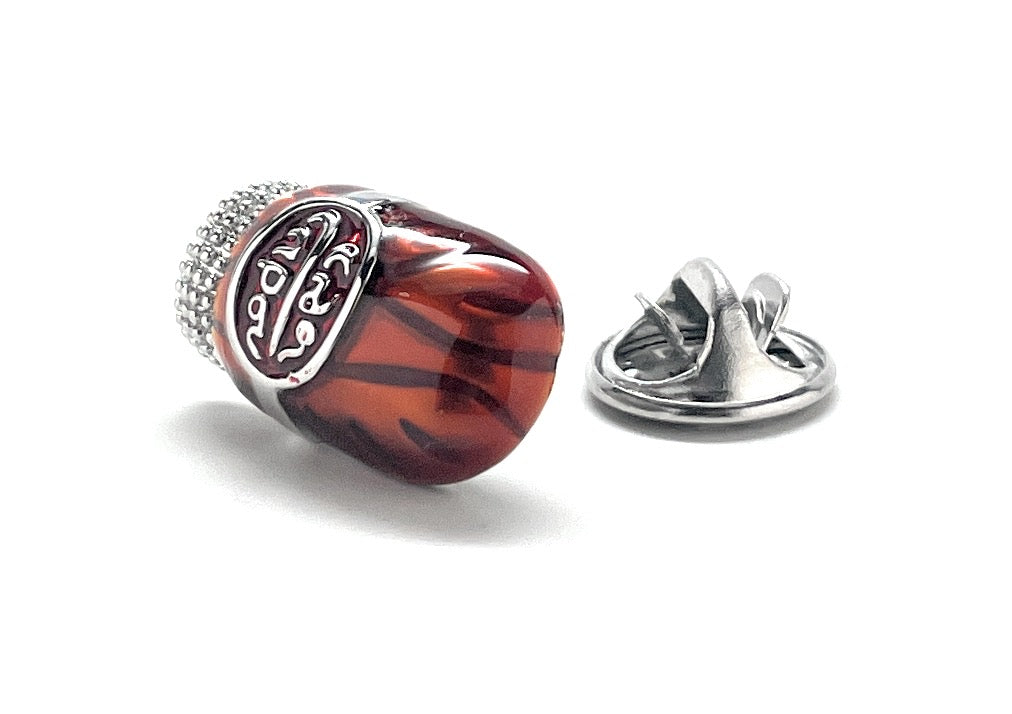 Red and silver brooch on a white background