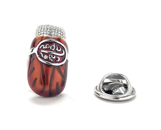 Decorative brooch with tortoiseshell design and silver accents on a white background