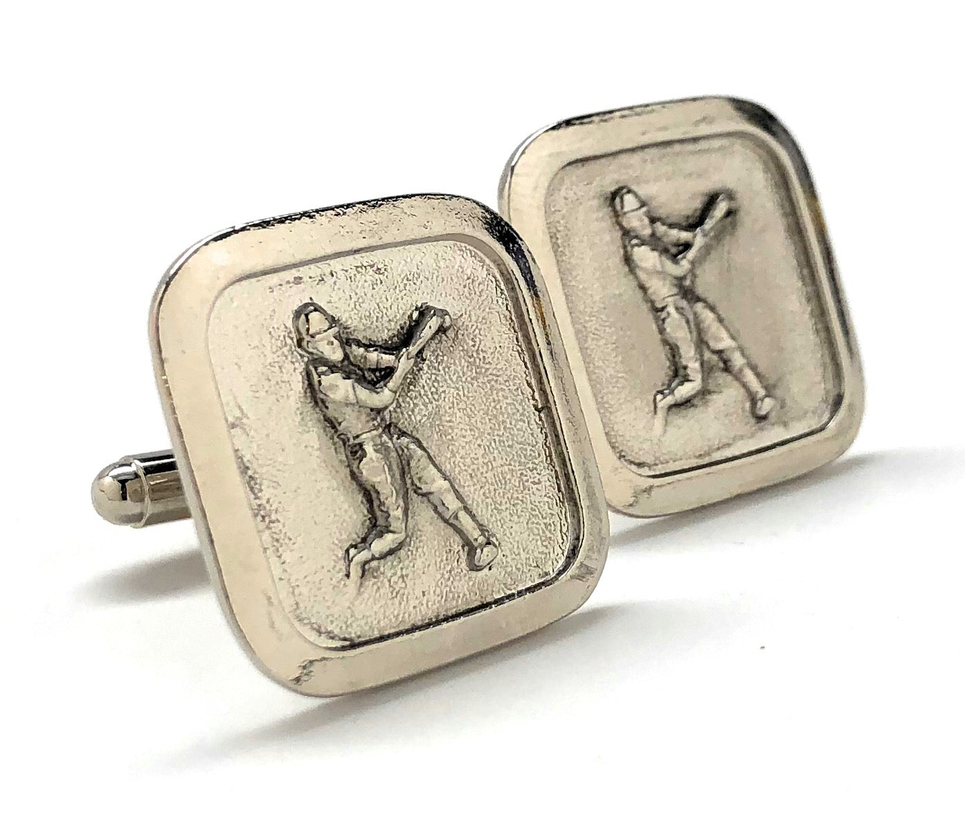 Silver cufflinks with golfing design on a white background