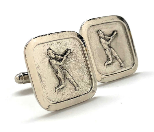 Silver cufflinks with golfing design on a white background