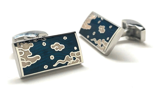 Pair of cufflinks with blue design and silver accents on a white background