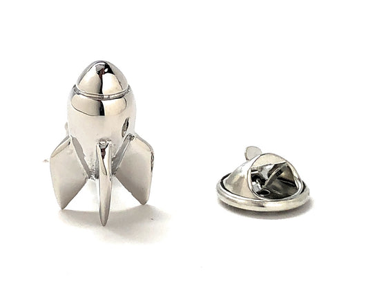 Metallic rocket-shaped pin on a white background