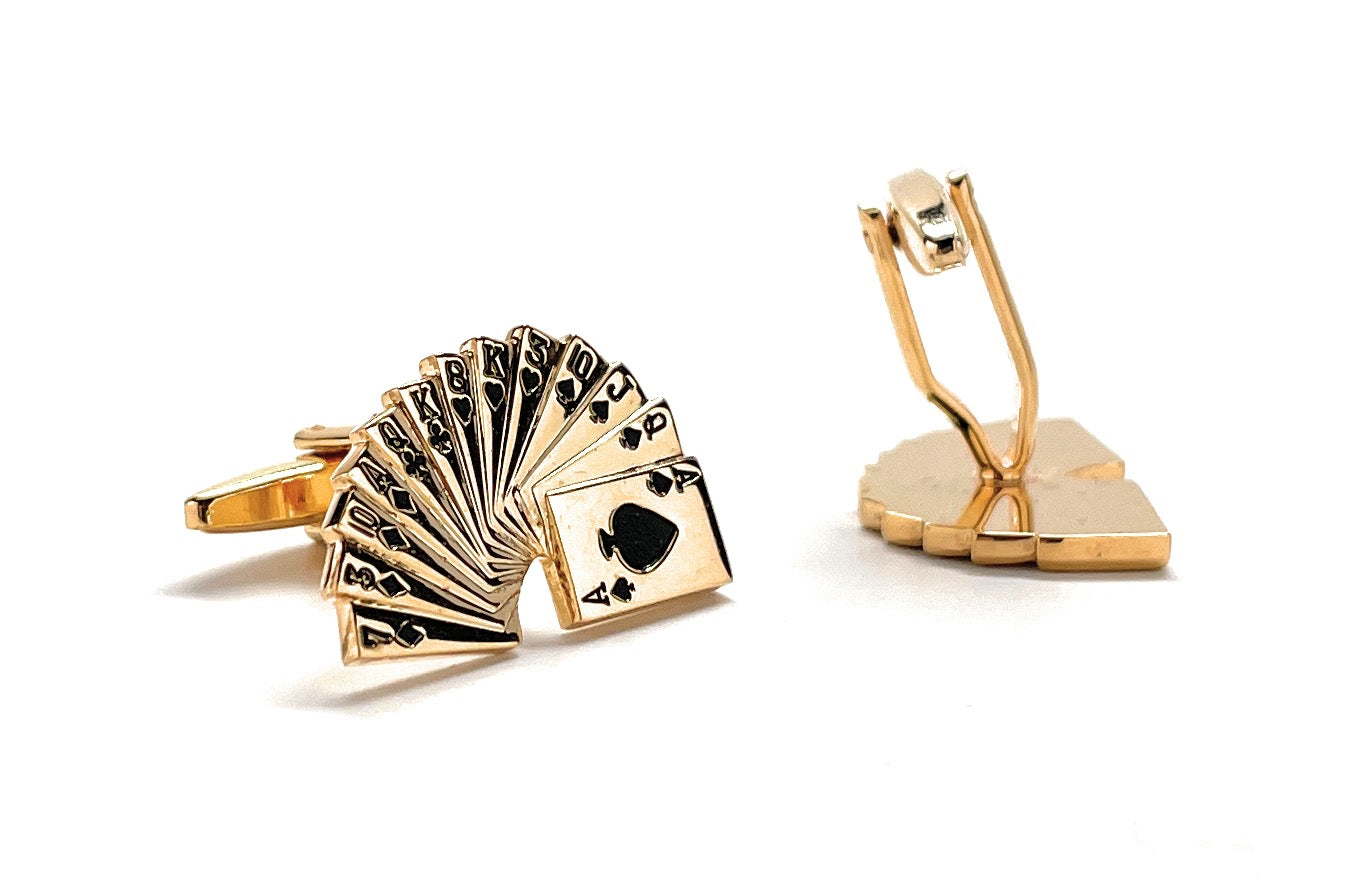 Gold cufflinks with playing card design on a white background
