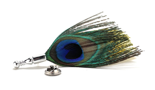 Peacock feather lapel pin with blue and green eye pattern and silver pin backing.