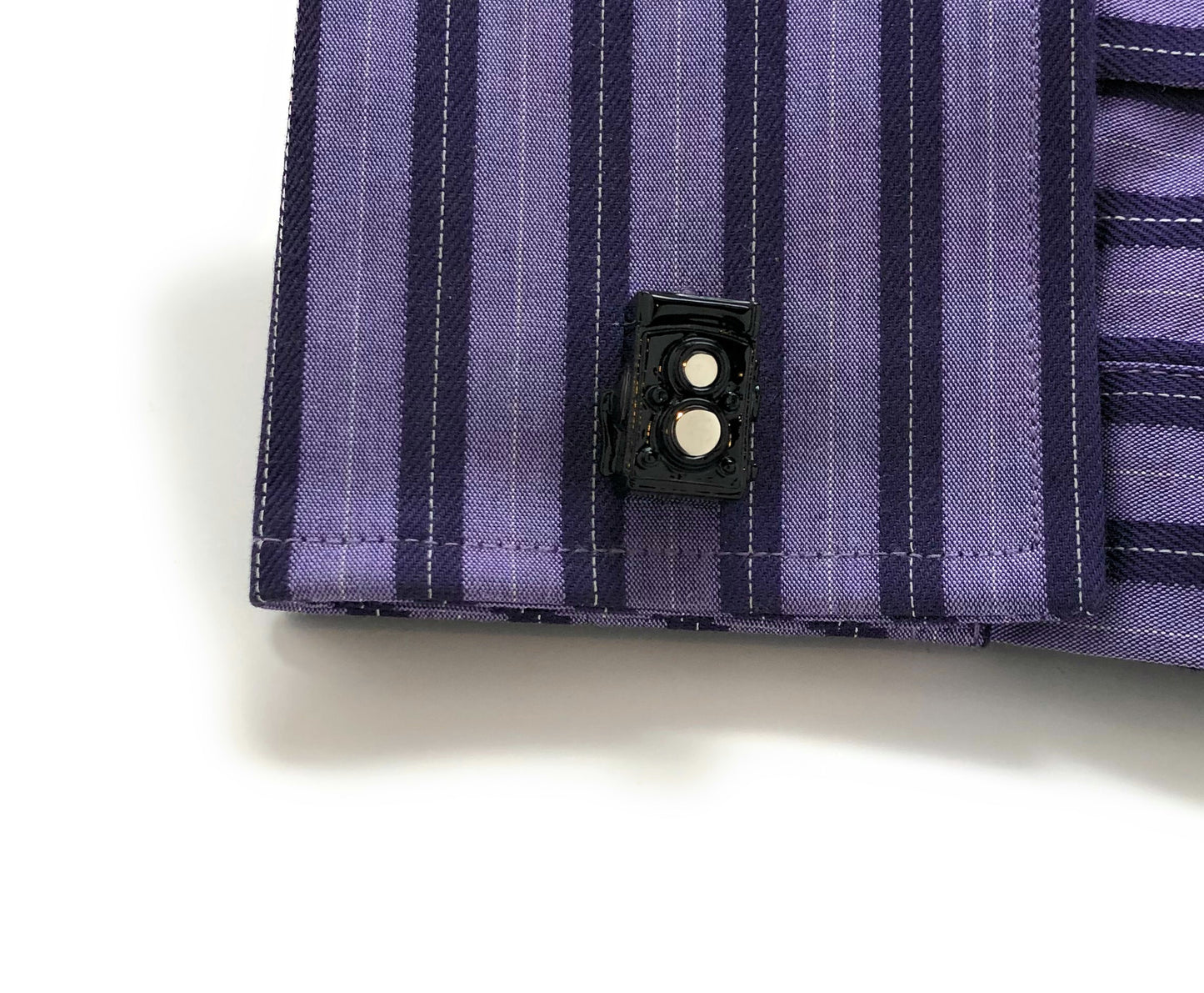Vintage black enamel twin-lens reflex camera cufflinks with silver bullet-back closure – photographer gift accessory on purple shirt