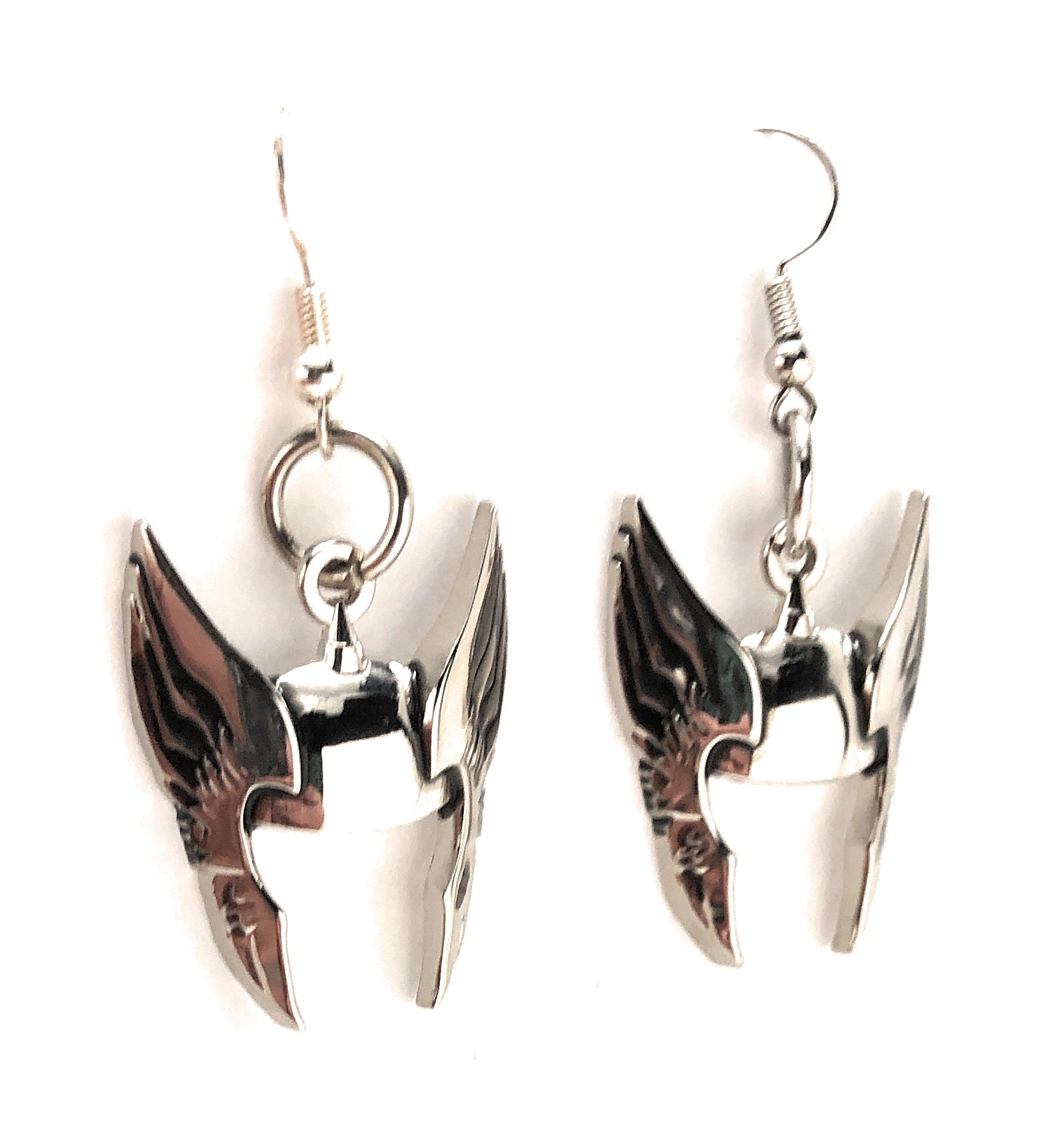 Pair of silver wing-shaped earrings on a white background