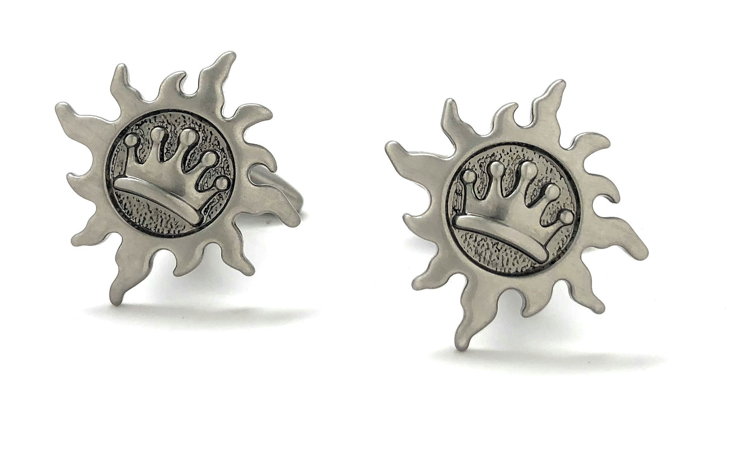 Pair of silver sun-shaped earrings with a central emblem on a white background